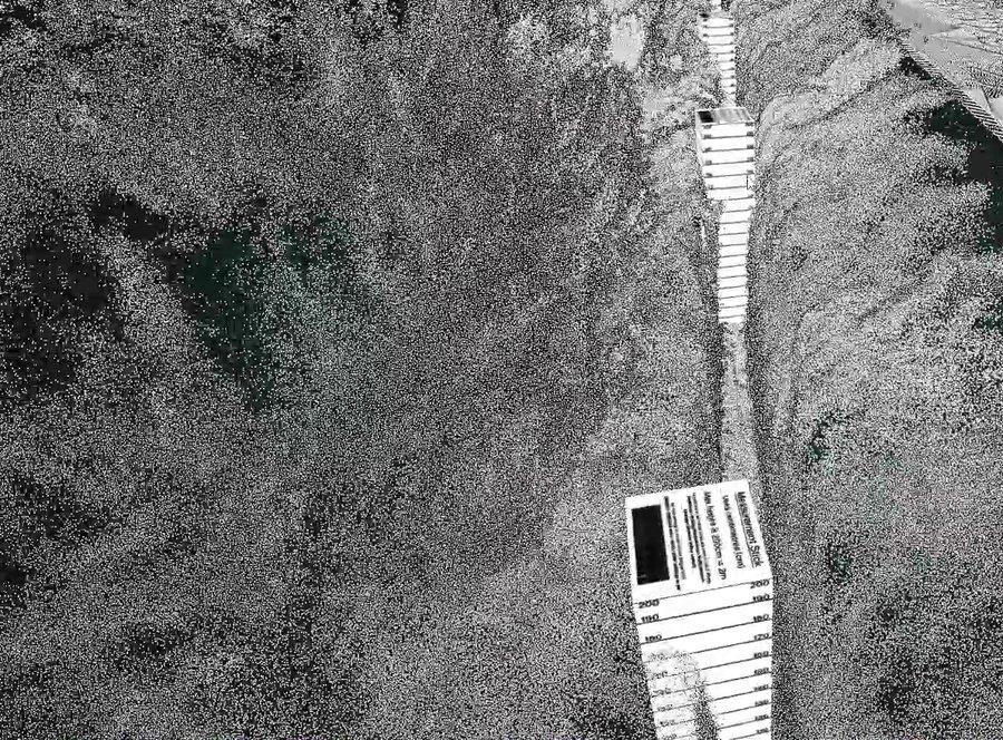 A scanned stretch of trench with two measuring staffs standing in it, one near and one further down the run